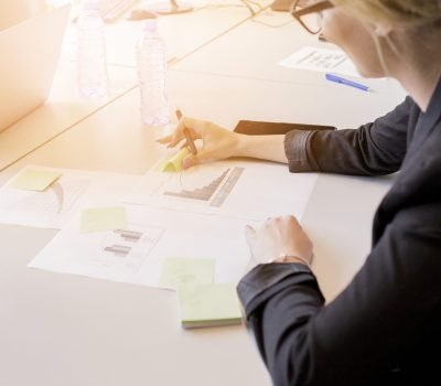 close-up-businesswoman-looking-sticky-notes-graph